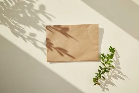 Craft paper envelope mock up under sunny shadows. Copy space Stock Photos