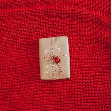 Craft rustic present on knitted red background Stock Photos