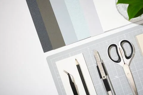 Craft tools flat lay on gray cutting mat. Scissors, utility knife, tweezers.. Stock-Fotos
