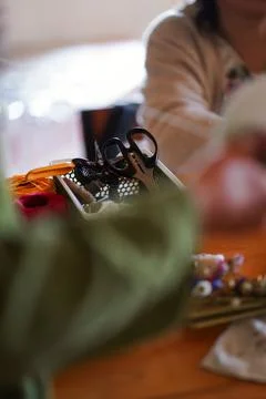 Craft tools with scissors and threads in a container on wooden table indoors Stock Photos