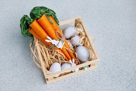 Craft wool thread carrots and easter eggs on gray background. Minimalist de.. Stock Photos