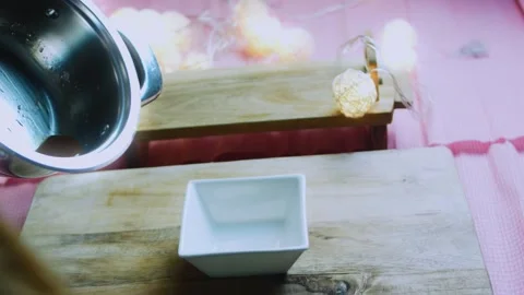 Crafted cooking study of pouring amber caramel into a white square mold Stock Footage 342153973