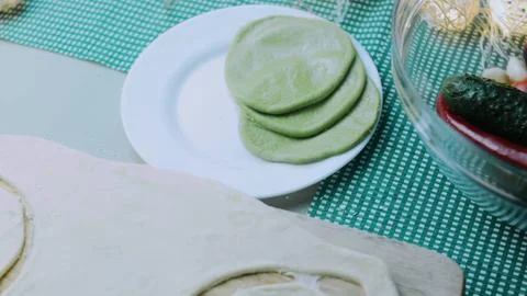 Crafted culinary scene: rolling colorful dough into a circle Stock Photos
