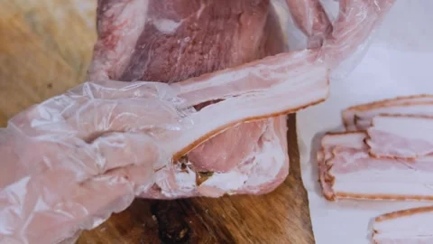 Crafted dynamic preparation: weaving bacon over the pork roll Stock Footage 342184717
