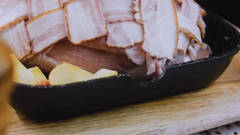 Crafted finished dish: placing bacon wrapped pork in a roasting pan Stock Footage 342184869