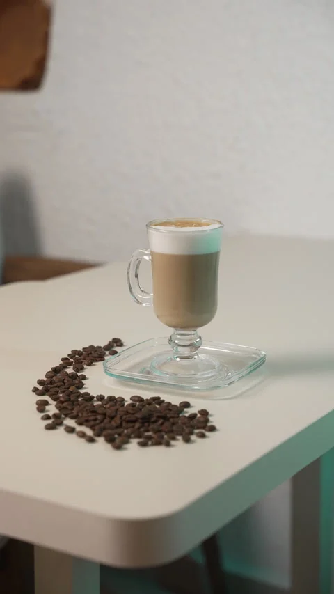 Crafted latte is presented on a table, accompanied by coffee beans Stock Footage 315298778