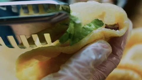 Crafted serving composition: adding creamy pickle sauce to a lettuce wrap Stock Photos