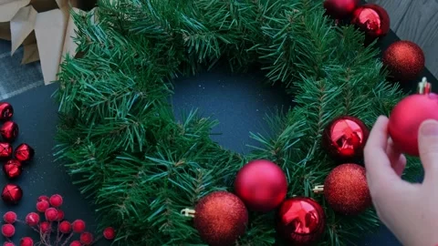 Crafter using hot glue Handmade Christmas wreath from festive red decorations Stock Footage 283871812