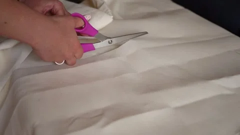 Crafting a beautiful table cover by cutting and shaping fabric at home Stock Footage 318903703