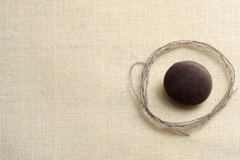 Crafting beauty with thread and button on a soft fabric backdrop Foto stock