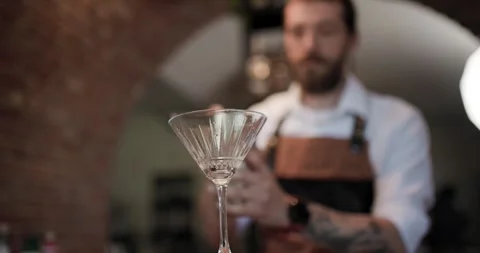 Crafting a cocktail in a busy bar as a skilled barman mixes a delicious drink Stock Footage 323406830