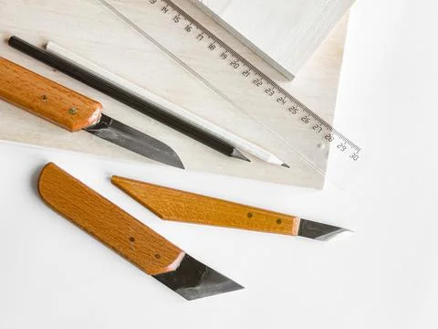 Crafting essentials. Precision knives, ruler, and pencil on wooden surface Stock Photos
