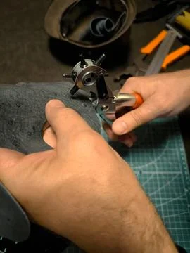Crafting with a Leather Hole Punch Tool on a Project in Almaty. Fotos Stock