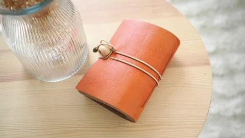 Crafting a leather notebook on a wooden table Stock Footage 334093328