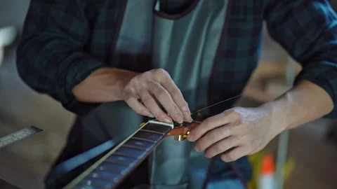 Crafting Musical Strings: Hands of an Artisan Working on Guitar Maintenance.. Stock Footage 327884377