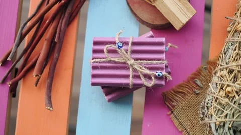 Crafting natural soaps and herbs on a colorful table in a sunny workshop 스톡 동영상 346666032