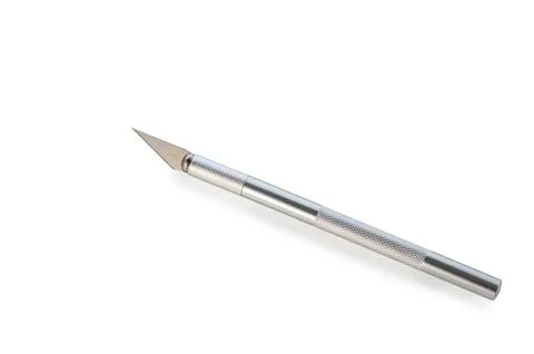 Crafting precision with a sharp metal tool on a clean white surface Stock Photos