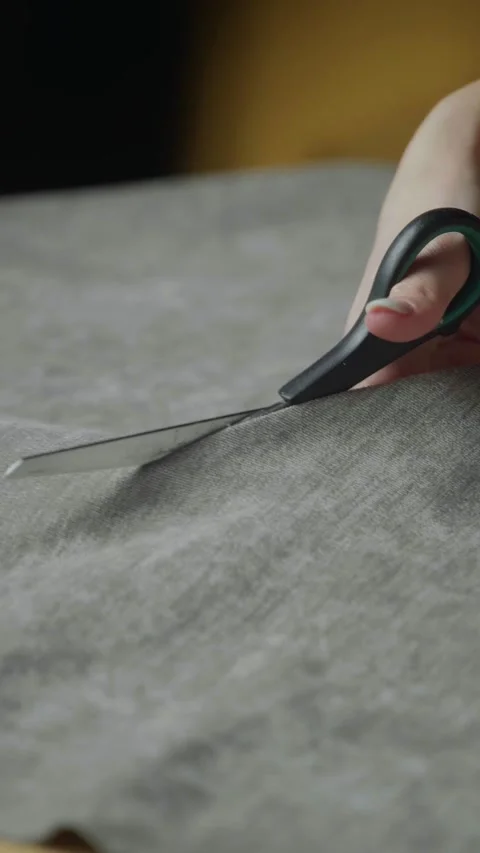 Crafting with precision while cutting fabric in a cozy workspace Stock Footage 303768681