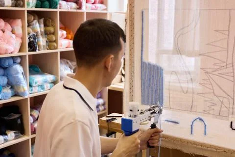 Crafting a tapestry with precision and skill in workshop setting Stock Photos