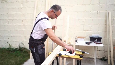 Crafting wooden projects in a backyard workshop during a sunny afternoon Stock Footage 290009723
