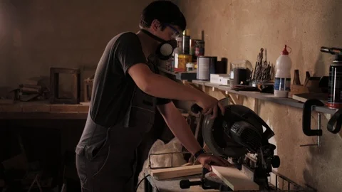 The craftman is working on electric saw machine. Sawing a large wooden board. Stockbeeldmateriaal 110341279