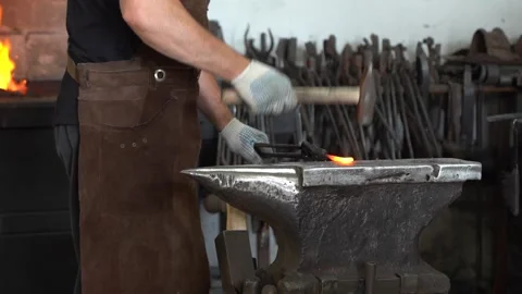 Craftsman in Action: A Skilled Blacksmith Forging Metal with Precision at the Stock Footage 341316882