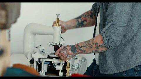 Craftsman adjusting a specialized machine for leatherwork. integration of manual Video stock 297922468