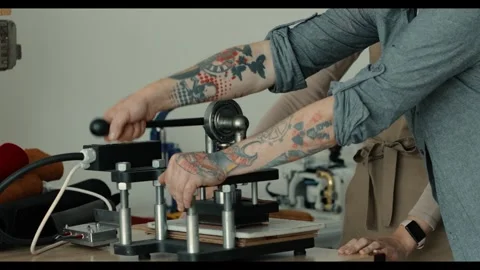 Craftsman adjusting a specialized machine for leatherwork. integration of manual Video stock 298957979