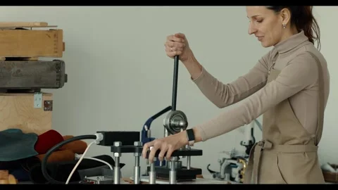 Craftsman adjusting a specialized machine for leatherwork. integration of manual 動画素材 298958290