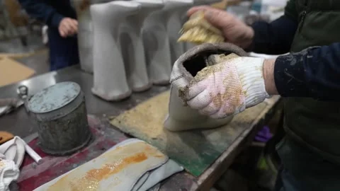 Craftsman applying cement with a brush along the seam of a rubber boot mounted Stock Footage 342897427