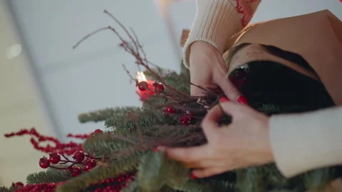 Craftsman arranges winter greenery with berries and twine. Home artisan Stock Footage 338287875