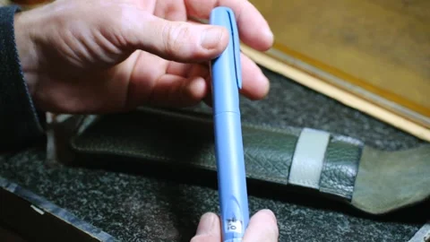 Craftsman assembling insulin pen for diabetic customer Stock Footage 296749836