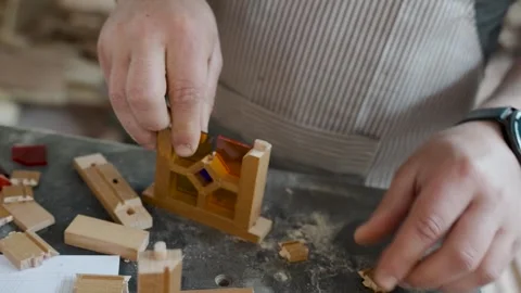 Craftsman assembling a miniature wooden frame with colorful stained glass p.. Stock Footage 334740465