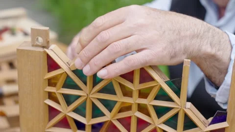 Craftsman assembling a miniature wooden frame with colorful stained glass p.. Stock Footage 334740579