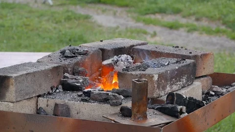 Craftsman blacksmith warming a of iron in the fire Stock Footage 129882240