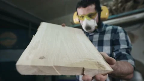 Craftsman carpenter at work. A man looks at a wooden blank, checks the surface. Video stock 196012809