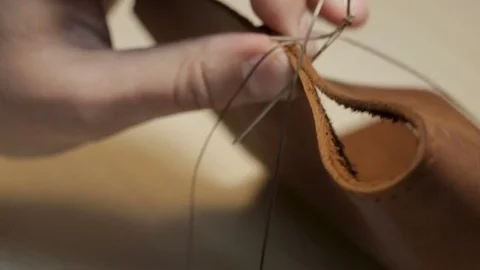 The Craftsman create a brown leather wallet with his own hands with a needle, Stock Footage 82056311
