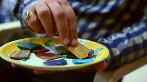 A craftsman displays array of semi precious stone for carving marble designs Stock Footage 51296160