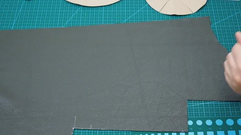 Craftsman draws cutting pattern of the bottom of pouch using paper pattern Stock Footage 97414971