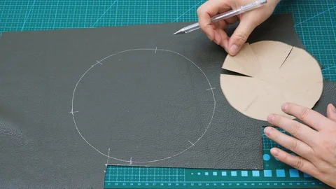 Craftsman draws cutting pattern of the pouch pockets using paper shape Stock Footage 97415049