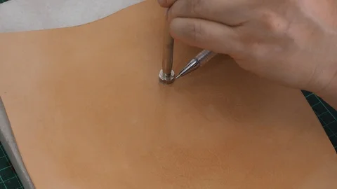 Craftsman draws the shape to draw the pattern on  leather before carving Stock Footage 97416125