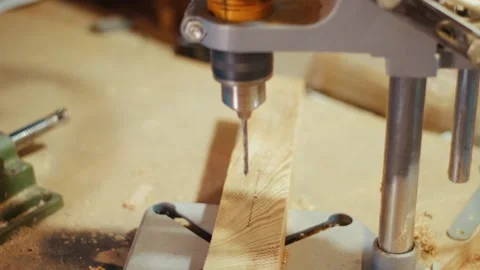 Craftsman drilling wood with drill press in workshop Stock Footage 346797364