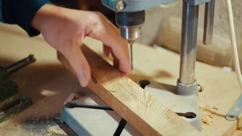 Craftsman drilling wood with drill press in workshop Stock Footage 346797409