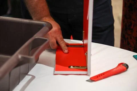 Craftsman expertly assembling a vibrant red display. A scene of dedication an Stock Photos