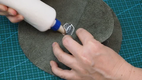 Craftsman glues the details of the pouch using  soft hammer Stock Footage 97415171