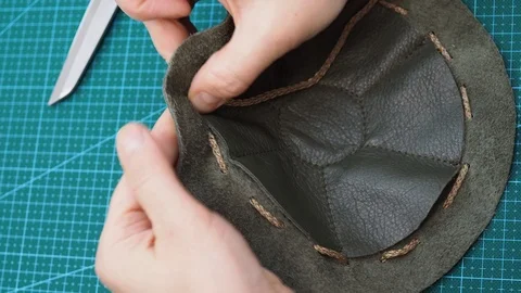 Craftsman inserts a cord in the sewn pouch Stock Footage 97415713