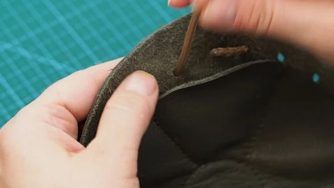 Craftsman inserts a drawstring in the sewn pouch Stock Footage 97415624