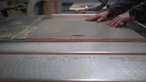 A craftsman makes precise cuts using a table saw in a busy workshop. Stock Footage 332227481