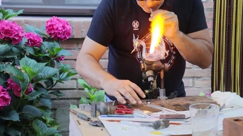 Craftsman making a glass figure with a blowtorch Stock Footage 245223353