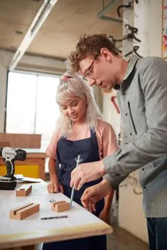 Craftsman Mentoring Female Apprentice In Workshop Building Sustainable Bamboo Stock Photos